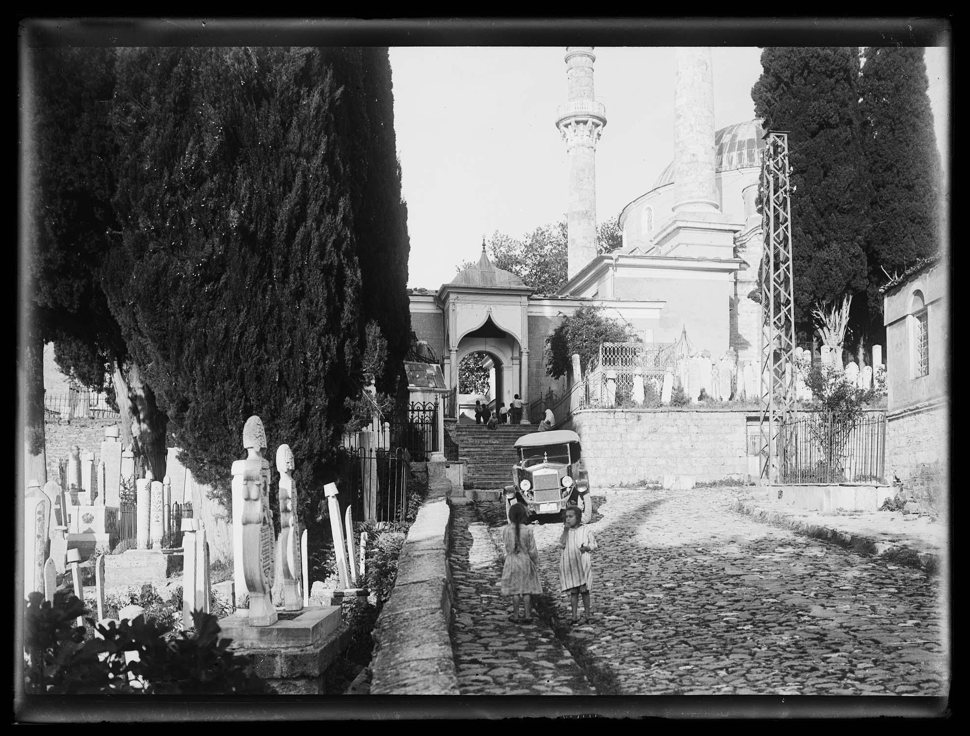 Entrée de la mosquée sur la rue, avec une automobile au premier plan